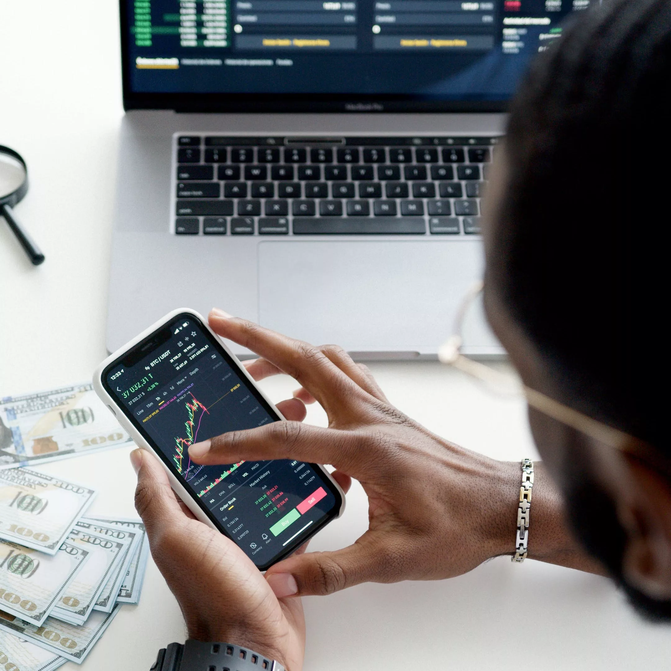 man using his smartphone to look at investments